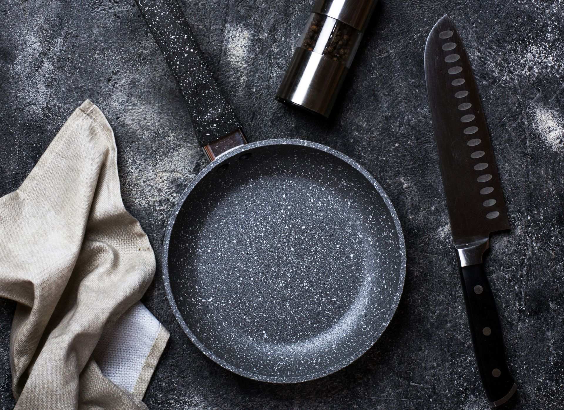 Frying pan and sharp knife on granite worktop