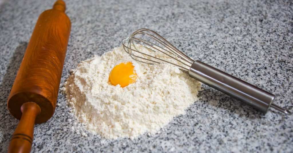 Baking ingredients and baking utensils on granite worktop